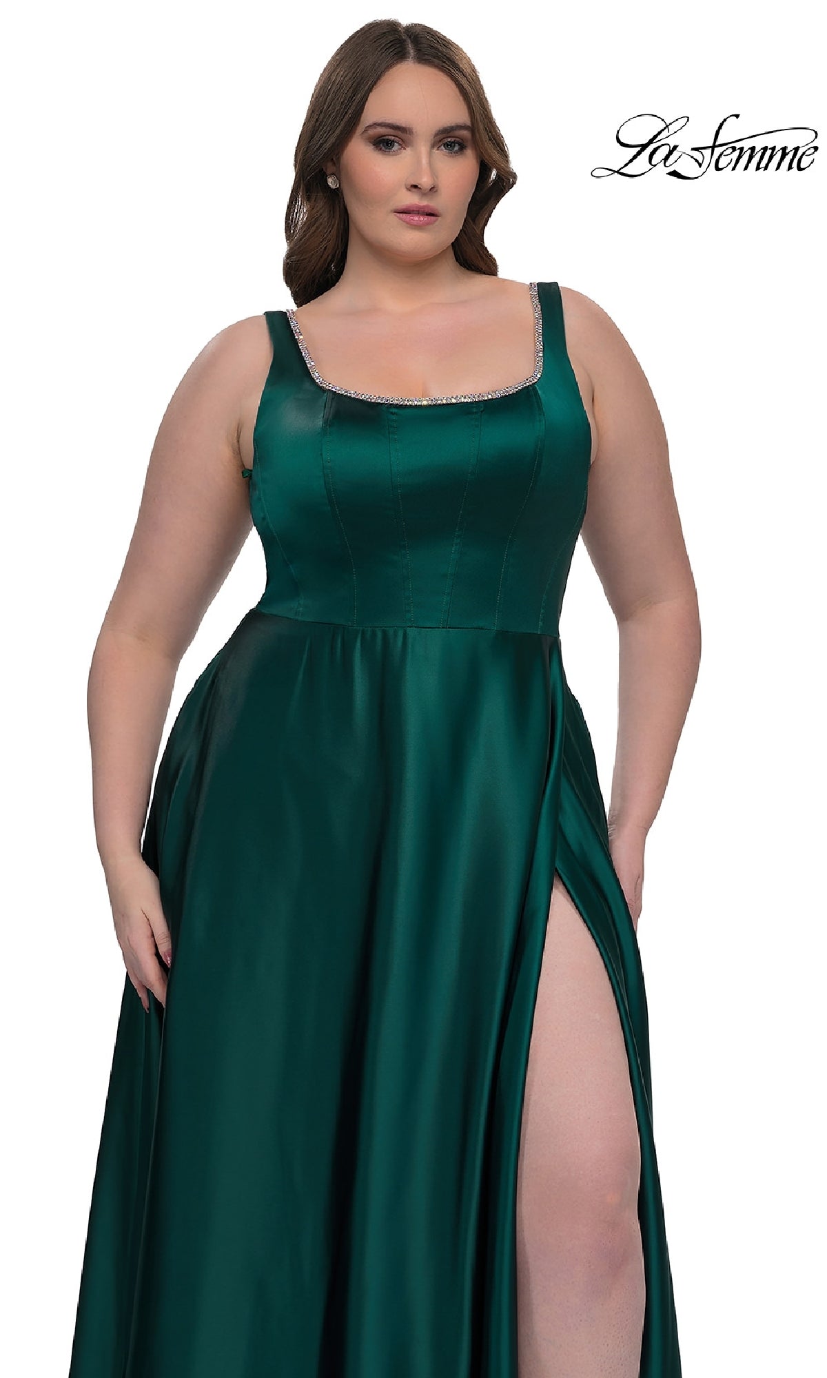 A woman models the Plus-Size Classic Long Prom Gown, La Femme 33026, featuring sleeveless emerald green satin, a square neckline, and thigh-high slit, posed against a white background with the